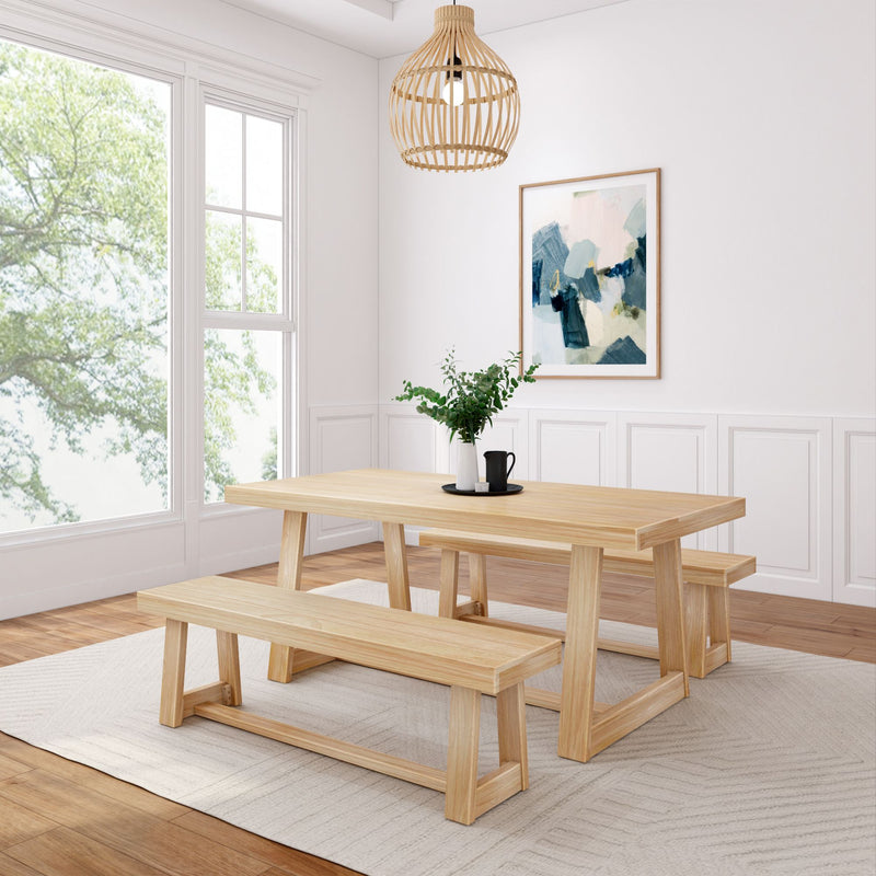 Modern dining room with light wood table and benches, white walls, and large window view of green tree.
