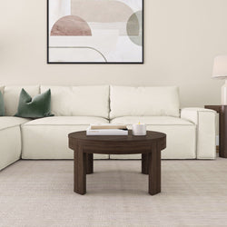Modern living room with a white sectional sofa, dark wood coffee table, and abstract wall art.