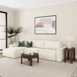 Beige modern living room with white sectional sofa, dark wood coffee table, and abstract wall art.