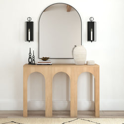 Modern minimalist entryway with wooden console table, large mirror, decorative vases, and wall sconces.