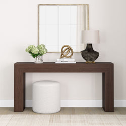 Modern living room decor with a brown console table, mirror, lamp, vase of flowers, and decorative objects.