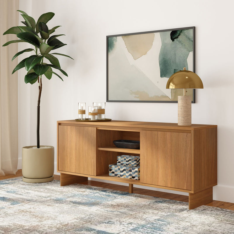 Mid-century modern oak sideboard console table in living room with gold dome lamp, abstract wall art, potted fiddle leaf fig, decorative storage boxes and textured area rug