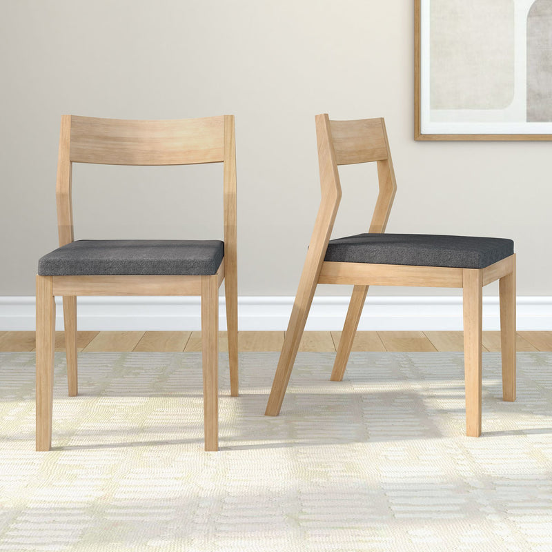 Modern wooden dining chairs with grey cushions on a light rug in a minimalist room setting.