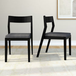 Modern black dining chairs with grey cushions in a contemporary living room setting.