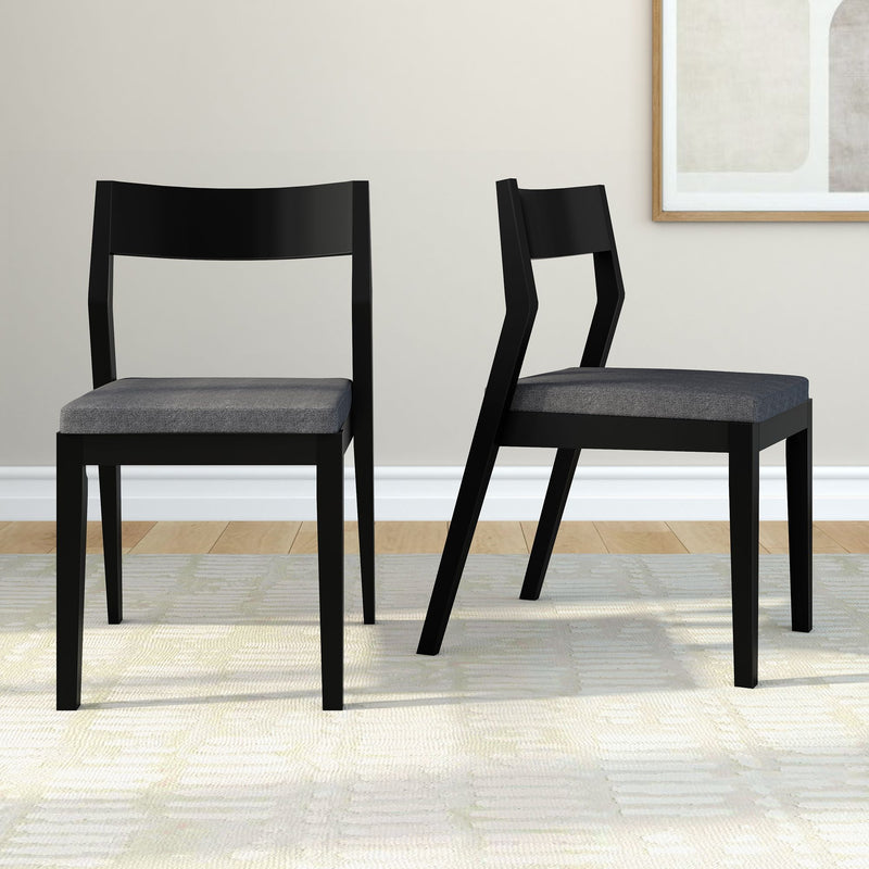 Modern black dining chairs with grey cushions in a contemporary living room setting.