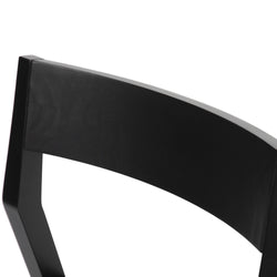 Black wooden chair backrest detail, modern furniture design.