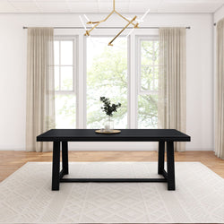 Modern black dining table in bright room with large windows, elegant chandelier, and minimalistic decor.