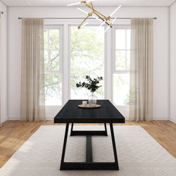 Modern dining room with black wooden table, decorative plant centerpiece, large windows, and elegant chandelier.