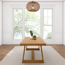 Modern dining room with wooden table, potted plants, large windows, and woven pendant lighting.