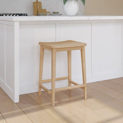 Natural wood bar stool in modern kitchen with white cabinetry and marble countertop.