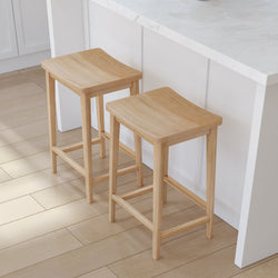 Two wooden bar stools placed next to a kitchen island with white marble countertop.