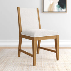 Oak wood dining chair with white textured upholstered seat and back, Scandinavian mid-century modern design in a neutral dining room