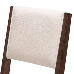 Beige textured fabric on dark wooden chair backrest.