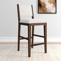 Stylish wooden bar stool with white cushioned seat in modern interior setting.