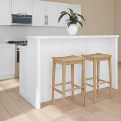 Modern kitchen with white cabinets, marble countertops, and wooden bar stools.