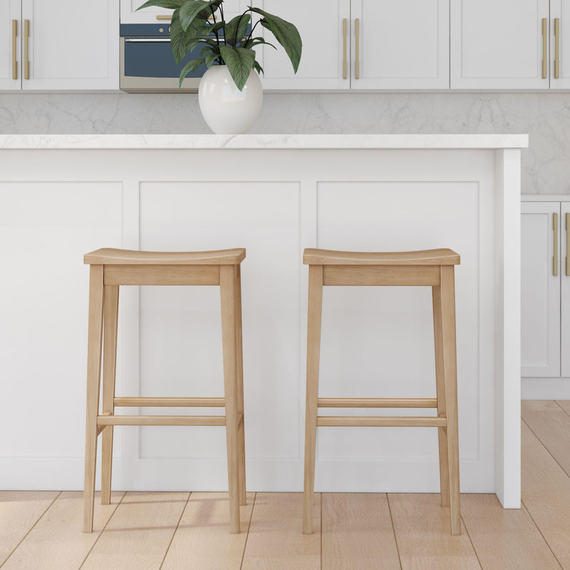 Minimalist kitchen design featuring two wooden bar stools and white cabinetry with marble countertops.