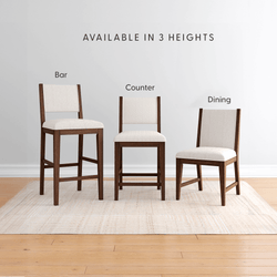 Modern upholstered walnut dining chairs in beige fabric shown in three heights: bar stool, counter stool, and dining chair on a light rug over hardwood floor