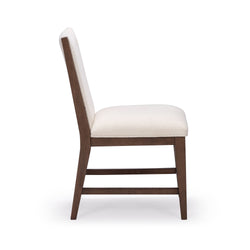 Side view cream upholstered dining chair with walnut wooden frame and horizontal stretchers, modern mid-century dining or kitchen chair