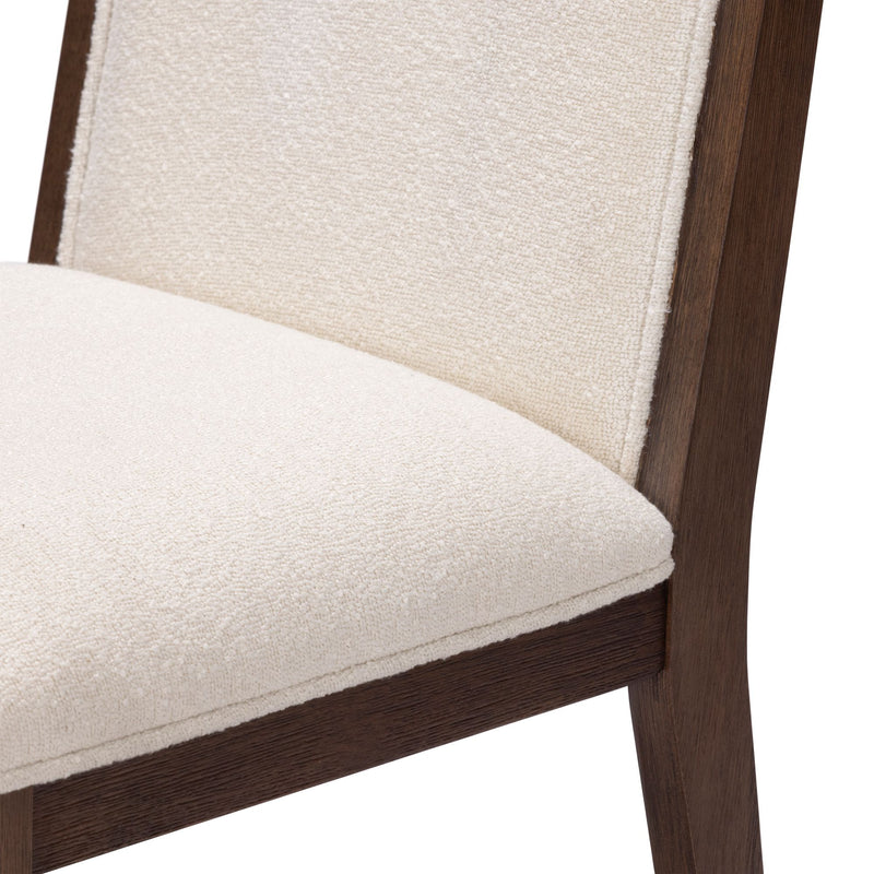Close-up of cream boucle upholstered dining chair seat and back with dark walnut wood frame, padded dining chair