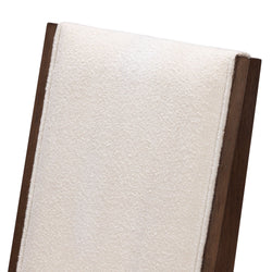 Close-up of upholstered dining chair back with cream boucle fabric and dark walnut wood frame, textured modern design