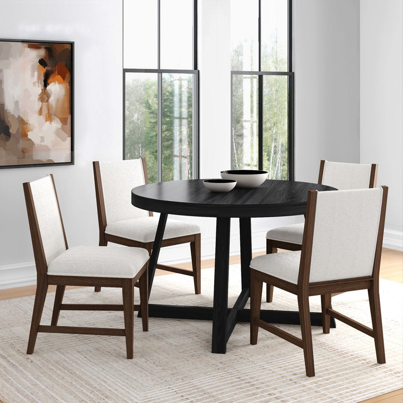 Modern round black dining table with four white upholstered wooden chairs in a bright minimalist dining room with large windows and abstract wall art.