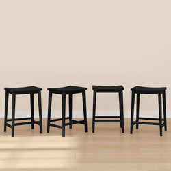 Set of four modern black bar stools on wooden floor against beige wall.