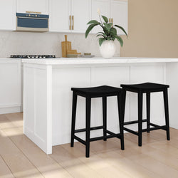 Modern kitchen interior with white island and two black bar stools.