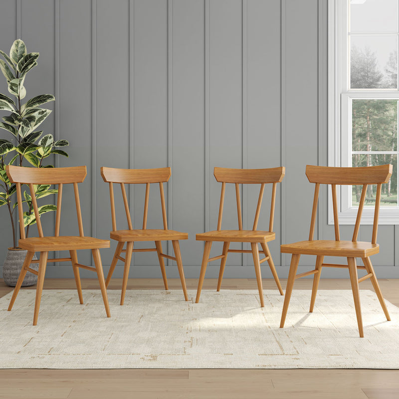Set of four wooden dining chairs with mid-century modern design in a stylish indoor setting.