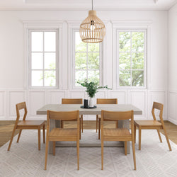 Modern dining room with wooden chairs, rectangular table, and pendant light fixture.