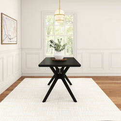 Modern dining room with minimalist black table, white vase centerpiece, and abstract wall art.