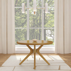 Modern round wooden table in a bright room with large window and elegant chandelier.