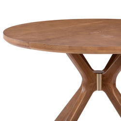 Round wooden dining table with unique leg design.