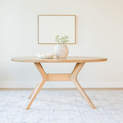 Modern wooden dining table with a minimalist design in a bright, airy room.