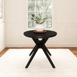 Modern black round table with a white vase centerpiece in a bright room with large window view.