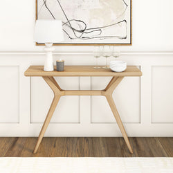 Modern minimalist wooden console table with decorative items in a stylish interior setting.