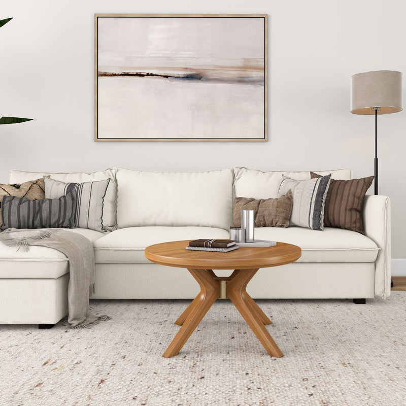Contemporary living room with a white sofa, patterned cushions, wooden coffee table, and abstract wall art.