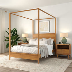 Modern wooden four-poster canopy bed with neutral bedding, mid-century nightstands, green table lamps, indoor plant and area rug in a bright minimalist bedroom