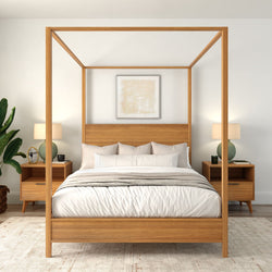 Minimalist modern bedroom with wooden four-poster canopy bed, neutral bedding, matching mid-century nightstands, green table lamps and potted plant.