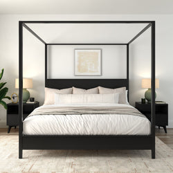 Modern black four-poster bed with white linens, beige throw and pillows in a minimalist neutral master bedroom with matching black nightstands, green lamps and potted plant