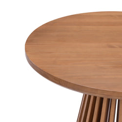 Round wooden dining table with a slatted base design.