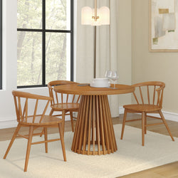 Modern round wooden dining table with matching chairs in a bright dining room setting.