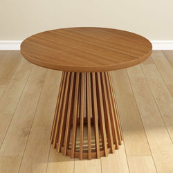 Round wooden pedestal table with modern slatted design on light hardwood floor.