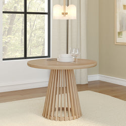 Contemporary round wooden dining table in minimalist dining room with modern lighting fixture.