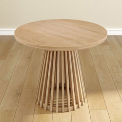 Round wooden table with unique slatted base on hardwood floor, modern minimalist furniture design.