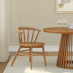 Wooden dining chair beside round table in modern minimalist dining room.