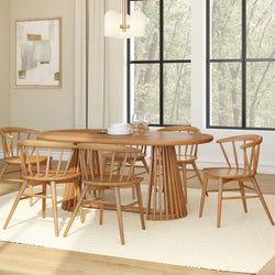 Mid-century modern round natural wood dining table with six spindle-back chairs on cream rug by large black-framed windows