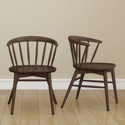 Two dark wooden chairs with spindle backs on a polished wooden floor, highlighting elegant home furniture design.