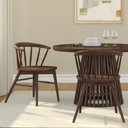 Modern dark wood dining set with round table and spindle-back chairs in a cozy dining room.