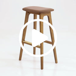 Mid-century modern solid wood bar-height stool with brown leather cushion and brass footrest