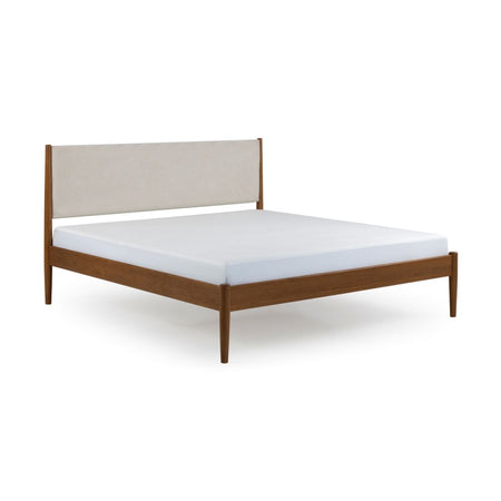 Mid-century modern walnut platform bed with cream upholstered headboard and white mattress on minimalist wooden frame